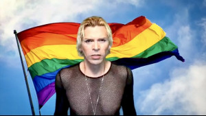 Aiden Vargas photo person wearing fishnet top standing in front of rainbow flag